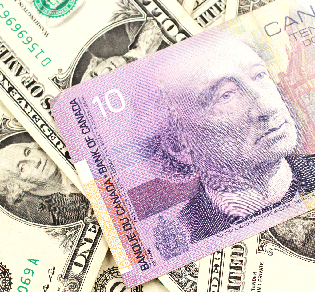 A Canadian ten dollar bill on a background of dollar bills