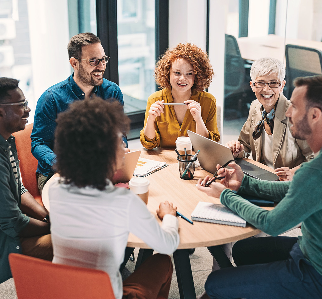 Mixed group of business people sitting around a table and talking